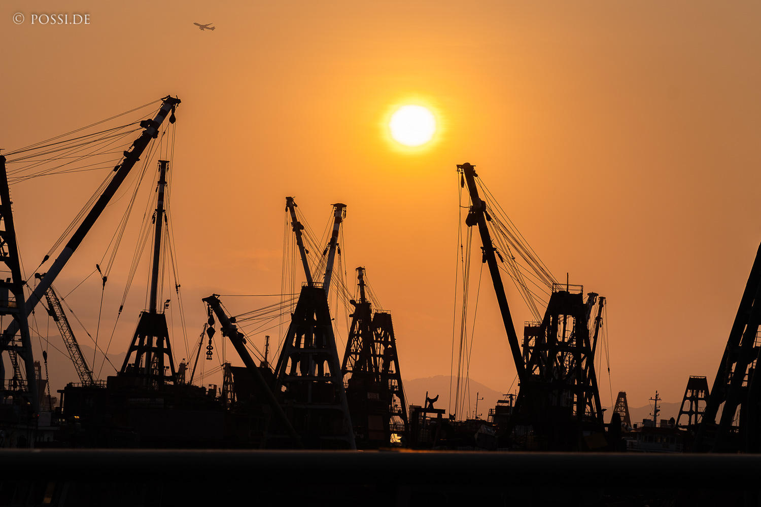 Die Sonne scheint hell und warm über den Hafen, während die Kräne stillstehen. (08.04.2025)